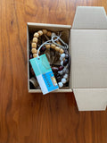 Colourful handmade beaded crossbody keyring in packaging, made from reclaimed wood and cotton cord