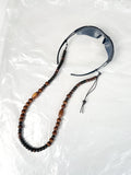 Handmade beaded glasses chain made from reprocessed wooden beads in brown, laid flat with eyewear