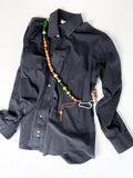 Colourful handmade beaded crossbody keyring worn on a shirt, made from reclaimed wood and cotton cord