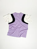 Upcycled panel T-shirt in lilac, black and white, made from second-hand T-shirts and deadstock jersey. Flat lay on white background.