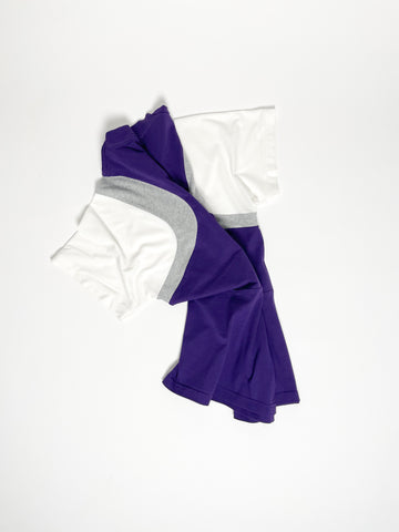 Upcycled panel T-shirt in purple, grey and white, made from second-hand T-shirts and deadstock jersey. Flat lay on white background.