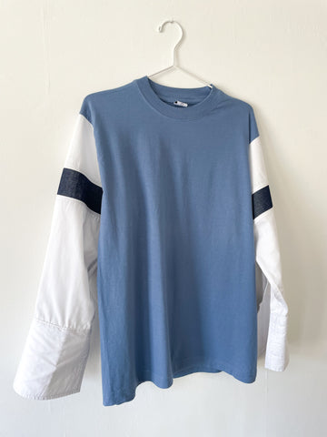 Blue T-shirt with white shirt sleeves and denim stripes on a white background.