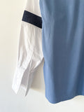 Detail of the cuff of a Blue T-shirt with white shirt sleeves and denim stripes on a white background.