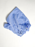 Light blue chambray boxer shorts with a board shorts-inspired design, featuring an elastic waistband, white drawstring, and relaxed fit.