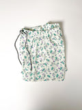 Green and purple Teddy bear print cotton boxer shorts with a board shorts-inspired design, featuring an elastic waistband, white drawstring, and relaxed fit.
